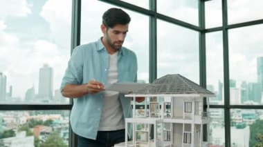 Tasarımlı ev modelini karşılaştıran profesyonel mimar mühendisi. İşadamı gayrimenkul projesine yatırım yapmaya karar verdi. Proje yöneticisi planla karşılaştırarak evi kontrol ediyor. İzleme