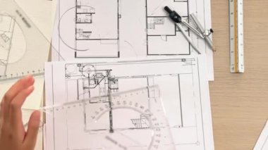 Akıllı mimar ya da akıllı mühendisin ölçüm aracı ve ahşap kalem el kullanarak mimari ofisindeki inşaat isabetinin planının detaylarını yazdığı bir video. Eline odaklan. Tanımlama.