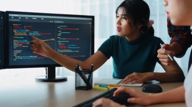 Yavaş çekim arkası yazılım geliştirici mühendisi bilgisayar programlama için birlikte çalışarak hata ayıklama kodunu çözüyor, ofiste monitörde karmaşık algoritmaları çözüyor. Filizlenen