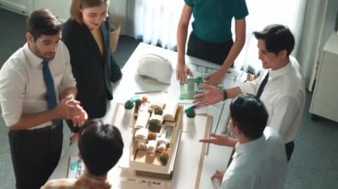 Ekibin el ele tutuşmasını ve toplantı masasında planı ve mimari modelle tezahürat ve cesaret verici bir ekip oluşturmasını yukarıdan aşağıya izleyeceğiz. Müdür alkışları başarılı projeye. Hizalama.