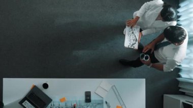 Mühendislik toplantısına katılırken ev tasarımına bakan Kafkas proje yöneticisinin yukarıdan görünüşü. Mimar mühendis grubunun planlara bakarken birlikte çalıştığı hava görüntüsü. Hizalama.