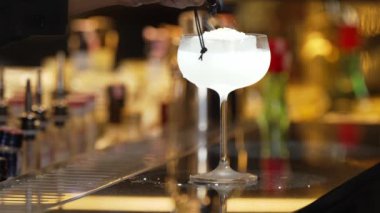 Gece kulübündeki lüks tezgah barda barmenin şeker sunumuna ateş yaktığı votka kokteyli. Gece hayatı karışımı sergilenen özel bir içecek Bokeh 'i sıcak ışığa davet ediyor. Vinosity.