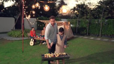 Aile birlikte bahçede kamp kurar, baba ve kız aile bireyleri için ızgara yapar. Doğayla iç içe olmak için açık hava kamp aktiviteleri ve genç nesil çapraz kuşaklarla zaman geçirmek için. Uyumsuzluk.