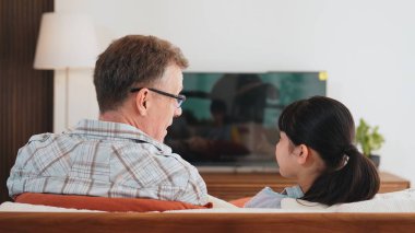 Büyükbaba ve torun birlikte TV 'de ilginç bir eğlence medyası izliyorlar. Eski üst düzey kullanım teknolojisi, genç nesil çapraz nesil ile iletişim kurarak aile bağlarını güçlendiriyor. Uyumsuzluk.