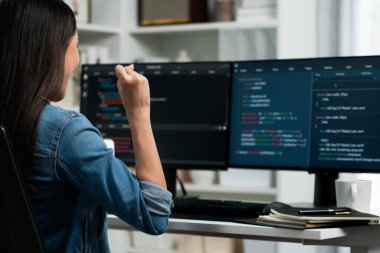 Genç Asyalı bilişim geliştiricisi, güvenlik analizi ekranı çerçevesinde kot gömlek giyen, kodlama programı veri uygulaması ile bilgisayardaki başarılı bilgilerle yumruğunu kaldırıyor. Taktik.