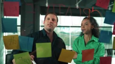 Yetenekli işadamı pazarlama fikrini cam duvardaki proje yöneticisine sundu. Yönetici projeyi yatırımcıya açıklıyor. Zeki iş adamları birlikte çalışıyor, beyin fırtınası yapıyorlar. Yönlendirici.