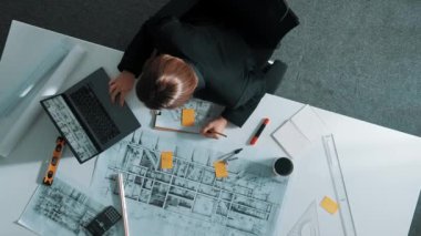 Planı ölçmek için cetvel ve ekipman kullanan inşaat mühendisinin en üst görüntüsü. Yapışkan notlar ve hesap makinesiyle bina inşaatı üzerinde çalışırken çalışan mimar. Hizalama.