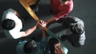 Zeki iş adamlarının birlikte çalışıp el ele tutuşması. Bir grup yetenekli iş adamının beyin fırtınası yapıp toplantı odasında el ele tutuşmalarının havadan görüntüsü. Sempozyum.