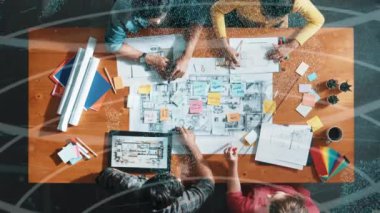 Sıradan giyinen, dizüstü bilgisayara bakan ve fikir paylaşan iş adamlarının en aşağıdan görünüşü. Yöneticinin hava görüntüsü çalışıyor ve masadaki renk paletini istatistiksel grafik hologramıyla kontrol ediyor. Sempozyum.