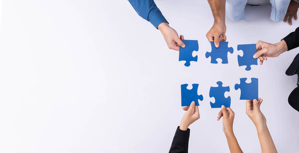 Top view panorama banner of business team joining jigsaw puzzle together over meeting table symbolize business partnership and collective unity teamwork in problem solving solution. Prudent