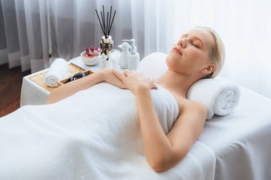 Kafkasyalı kadın müşteri stres önleyici spa masajının keyfini çıkarıyor ve lüks otel ya da oteldeki gündüz açık ortam güzellik salonunda güzellik teniyle eğleniyor. Sessiz.