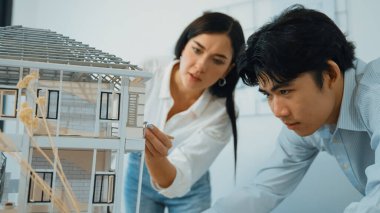 Modern ofisteki ev modeli yapısını kontrol etmeye odaklanan genç, profesyonel mimar mühendis ekibine yakın çekim. Yaratıcı profesyonel tasarım ve takım çalışması konsepti. Tertemiz..