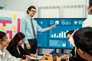 İş adamı, finansal rapor veri analizi veya pazar eğilimi gösterisiyle iş sunumunu şirketin gelecekteki yönetiminde stratejik planlama için büyük bir TV ekranında sundu. Habiliment