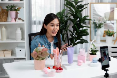 Kozmetik makyaj ve cilt bakımı koleksiyonunu inceleyen genç, güzel Asyalı müşteriler sosyal medyada konuşuyor. Güzellik ürünlerini sunuyorlar. Bulanık telefon kaydı yapıyorlar. Taktik.