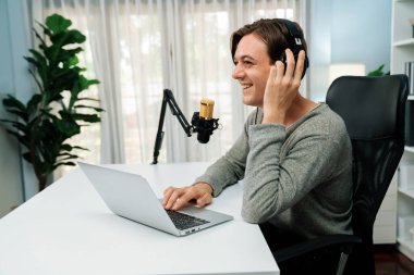 Sunucu kanalı, gülümseyen akıllı yayıncı kaydı, senaryosu ve akıllı telefonuyla sosyal medyada sohbet programı, kulaklık takarak modern ev stüdyosundaki video flamalarını kaydediyor. Bireysel.