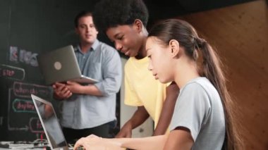 Çeşitli öğrencilerden oluşan bir grup program yazmak için birlikte çalışıyor. Öğretmenler BTMM dersindeki hata noktasını açıklarken çok kültürlü çocukların kodlaması ya da programlaması. Öğretim