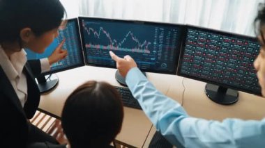 Menkul kıymetler borsası pazarlamasını inceleyen borsa yatırımcıları, zarar ve kazanç için mum bar fiyatlarını analiz eden monitörlere bakıyor. Filizlenen