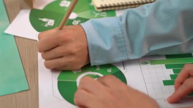 Mükemmel iş adamları, yeşil enerji grafiği kullanımı olan karmaşık bir masada eko ev projesini tartışıyor alternatif enerjiyi seçiyor ya da analiz ediyor, karbonu azaltıp dünyayı kurtarıyor. Eline odaklan. Tanımlama.
