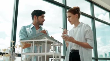 Yetenekli mimar mühendis takımı ev modeli inşaatı hakkında konuşuyor. Akıllı iç mimar paylaşımı, güzel bir iş arkadaşı not alırken bina tasarımından bahsetmek. Tasarım. İzleme