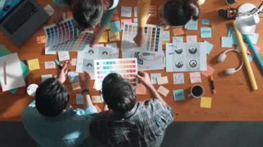 Renk paletlerine bakıp logo veya ürün için renk seçen akıllı yöneticinin üst görünümü. İş adamlarının hava görüşü proje için uygun bir beyin fırtınası teması oluşturuyor. Sempozyum.