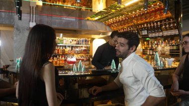 VIP grubu, barın önünde oturmuş arkadaşlarıyla ya da barmen hazırlarken karışık punç kokteyli içen çiftle yaşam tarzı seyahatlerini tartışıyor tezgahın üzerinde arka taraftaki süslü Noel ağacını hazırlıyor. Vinosity.