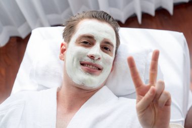 Kaplıca salonunun sakin atmosferi, insan müşterisi modern gün ışığında lüks yüz kremi masajıyla kendini yenileme zevkine kapılıyor. Yüz bakımı ve güzellik konsepti. Sessiz.