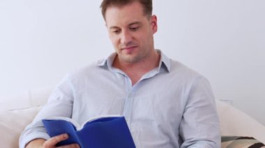 Kanepede oturan orta yaşlı bir adam, sosyal ve teknolojik mesleki gelişmeler hakkında ders kitabı okur ya da çocukları iyi bir yetişkin baba olmak için yetiştirir. Hayat boyu öğrenme konsepti. Uyumsuzluk.