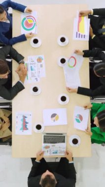 İş adamları grup toplantısı ofiste yukarıdan çekildi. İş kadınları, iş adamları ve ofis çalışanları, proje planlama belgeleriyle takım konferansında toplantı masasında çalışıyorlar. .