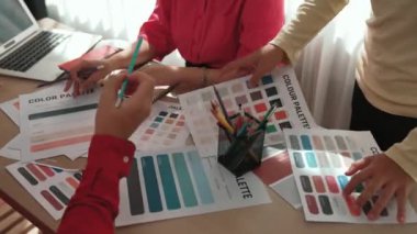 Tasarımcı ekibinin beyin fırtınası yaptığı ve grafik tasarımı için renk seçimi yaptığı el kapanışı ya da tasarım bürosunda krom danışmanlığı için danışmanlık isteyen bir müşteri. Değiştirilmiş
