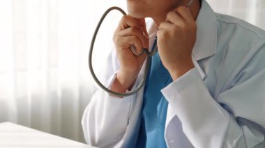 Hasta klinikte ya da hastane ofisinde doktor randevusuna gidiyor. Hastaların nabzını steteskopla kontrol edip risk faktörünü belirleyen doktor semptomları inceliyor. Panorama. Katı.