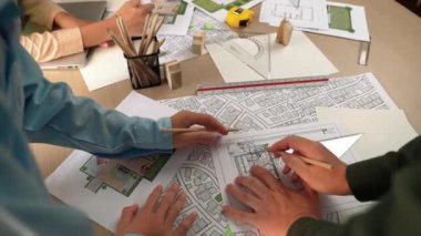 Mimari döküman, ölçüm araçları ve ahşap blokların modern ofiste etrafa saçıldığı masa üzerine planlar yapma konusunda akıllı mimar ve güvenlik mühendisi tartışması. - Yakın çekim. Tanımlama.