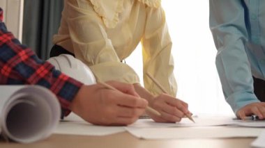 Mimari döküman, ölçüm araçları ve ahşap blokların modern ofiste etrafa saçıldığı masa üzerine planlar yapma konusunda akıllı mimar ve güvenlik mühendisi tartışması. - Yakın çekim. Tanımlama.