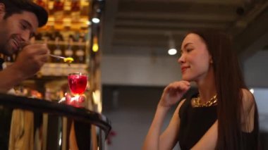 Barmen lüks tezgah barında güzel misafirler için çiçeklerle süslenmiş karışık votka kokteyli servis ediyor. Mükemmel canlı renk sunumu. Atmosfer gece kulübünü ön plana çıkarıyor. Vinosity.