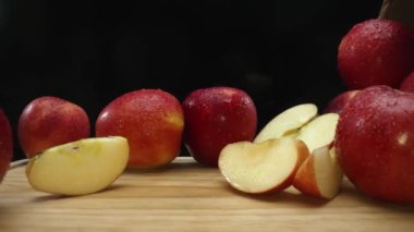 Makrografi, taze elma dilimleri çarpıcı bir siyah arka plana karşı bir kesme tahtasına yerleştirilmiştir. Her yakın çekim elmaların canlı dokusunu ve canlı renklerini yakalar. Geliştirilebilir.