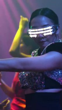 Bir grup insan disko gece kulübünde DJ 'in sahnede çaldığı müzikle dans ediyor. Yeni yıl partisi ve gece hayatı konsepti .