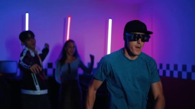 Kameranın önünde dans eden yetenekli break dansçı farklı arkadaşları pop ya da hip hop müziği dinlemek için arkada dans ediyor. Çekici performans ekibi kameraya doğru hareketli hareketler sergiliyor. Mutluluk.
