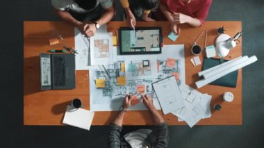 Toplantıda tablet kullanarak iç mimar planlama binasının üst hava görüntüsü. Bir grup mimar mühendis, fikir üretme ve ev yapısını tasarlama işini yönetime sunarken. Sempozyum.