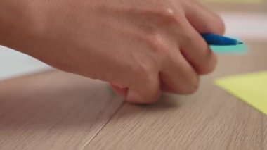 Yavaş çekimde, kadın iş kadını el yazısı pazarlama kâğıdı üzerine kalem ve yapışkan notlarla masaya yerleştirilmiş. Yaratıcı bir girişim ve takım çalışması konsepti. Eline odaklan. Değiştirilmiş.