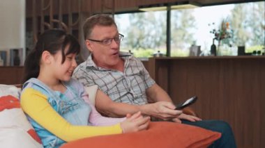 Dedem ve torunum TV 'de ilginç bir eğlence medyası izliyorlar. Genç nesil, yaşlı yaşlılara uzaktan kumanda teknolojisi kullanmayı öğretiyor. Nesiller arası uçurum aile bağını güçlendiriyor. Uyumsuzluk.