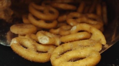 Dağılmış tuzlu krakeri bir paketin içinde saklayın. Hareket eden kamerayla yerleştirilmiş makro atıştırmalık. Stüdyo makro atıştırmalık ve baharat tozu. Tasarım ve baskı için alanı kopyala. Pabulum.