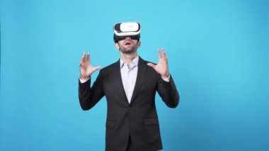 Yetenekli proje yöneticisi VR gözlük takıp online toplantıya katılırken pazarlama fikrini konuşuyor ve paylaşıyor. Zeki iş adamı mavi arka planda mali raporu birbirine bağlıyor. Aygıt.
