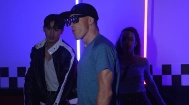Çeşitli insanlar arkadaşının arkasından yürürken, nedensel tişörtlü beyaz break dansçı. Çok kültürlü mutlu takım serbest stil müziğe geçiyor ya da partide ya da neon ışıklı evde dans ediyor. Mutluluk.