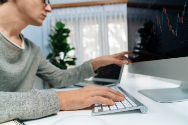 Bilgisayar ve dizüstü bilgisayarı kullanarak, çalışma masasındaki dinamik artırılmış borsa grafiğinin en yüksek kar değerini araştıran bir tüccar, modern ofisteki ekrandaki döviz kuru değerini analiz ediyor. Bireysel.