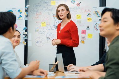 Profesyonel çekici kadın lider, modern iş toplantı odasında beyin fırtınası zihin haritalama istatistikleri ve renkli yapışkan notlar kullanarak yaratıcı pazarlama planını sunuyor. Tertemiz..