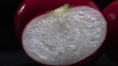 Dilimlenmiş taze turpun yakın çekimi siyah arka planda patlar. Canlı kırmızı et, karanlığa karşı bir işaret. Bu basit kompozisyon turpların eşsiz güzelliğini vurguluyor. Geliştirilebilir.