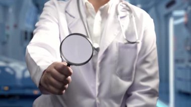 Doktorun elinde insan kalbi anatomisi hologramı olan büyüteçle laboratuvarda bulanık bir arka plan olan bir büyüteç tutmasına yakın çekim. Kalp röntgenini kontrol eden ve teşhis eden yetenekli bir tıp çalışanı. İyileştirici.