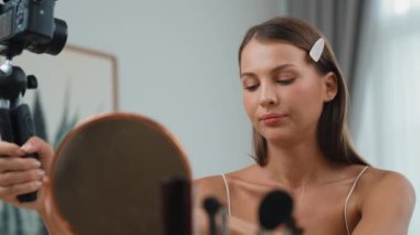 Sosyal medya için güzellik ve kozmetik video içeriği hazırlayan genç bir kadın. Güzellik blogcusu kameraya gülümserken seyircilere ve takipçilere güzellik bakımını gösteriyor. Düzenle