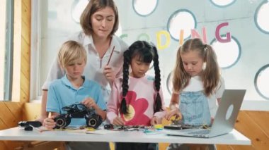 Öğretmen öğrencilere dijital elektrikli aletleri ya da araba modelini öğretir ve açıklar. Çeşitli çocuklar elektronik aletleri öğrenip ana kartı ya da kablolu robot modelini tamir etmeyi öğrenirler. Etkinlik.