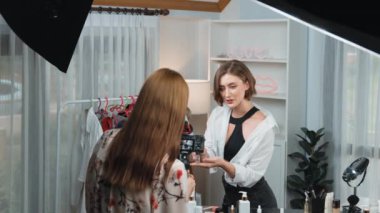 Etkilenen iki ortak canlı yayında video görüntülerini çekiyor makyaj malzemesi prim sosyal medya veya blog. Kozmetik stüdyosu ışıklandırmalı mutlu genç kız çevrimiçi pazarlama oturumu yayını için..