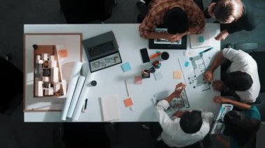 Üst düzey hava görüşlü iş adamları ev modeli ve dizüstü bilgisayarla iç mekan inşaatı hakkında beyin fırtınası yaparken mimar mühendisi de tasarım ve yazım işlerini planladı. Hizalama.